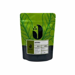 JAMAI CAFE Guatemala SHB Huehuetenango, zrnková káva 100 procent Arabica, sáček s listovým motivem a zelenou etiketou.