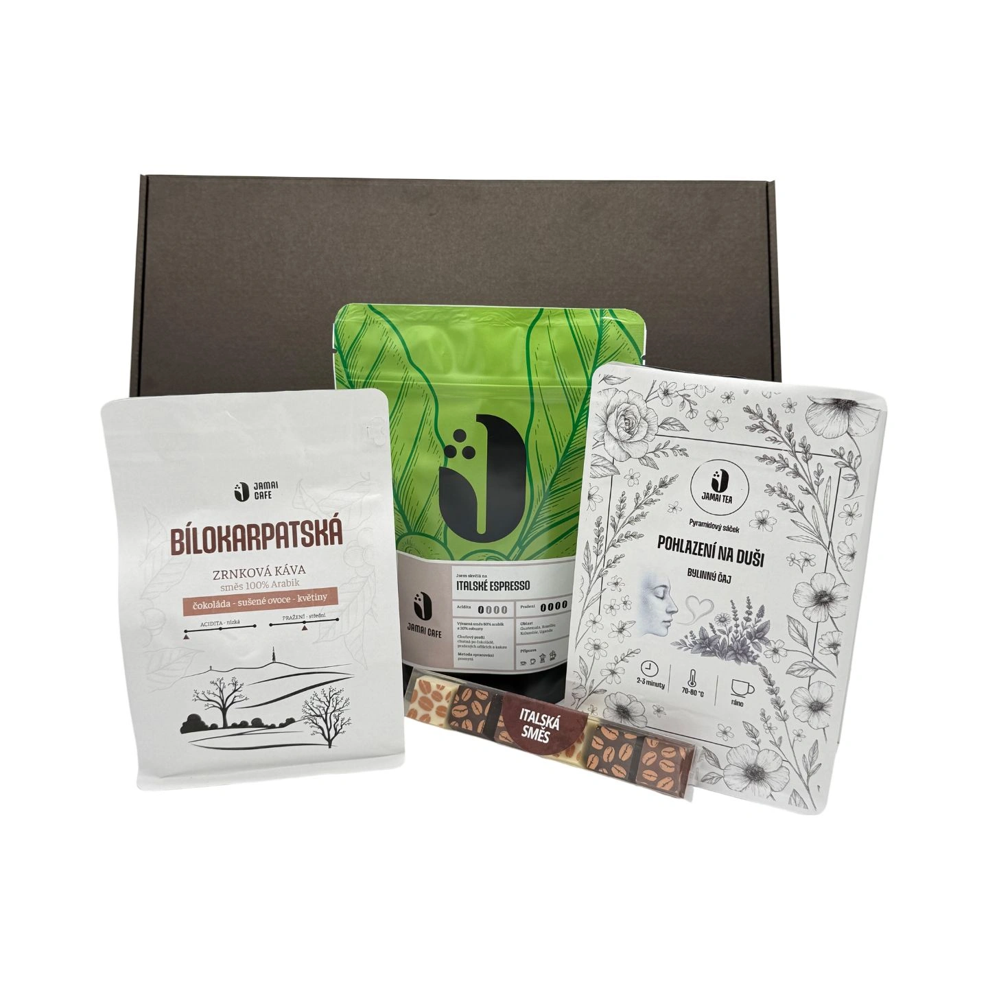 Dárkový balíček s kávou Bílokarpatská, kávou Italské espresso v zeleném sáčku, bylinným čajem Pohlazení na duši a tyčinkou čokolády Italská směs vystavený před černou dárkovou krabicí.