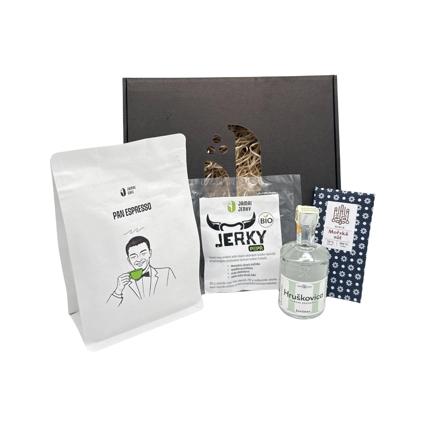 Dárkový balíček s kávou Pan Espresso, balením hovězího jerky, lahví hruškovice a tabulkou čokolády s mořskou solí vystavený před černou dárkovou krabicí.